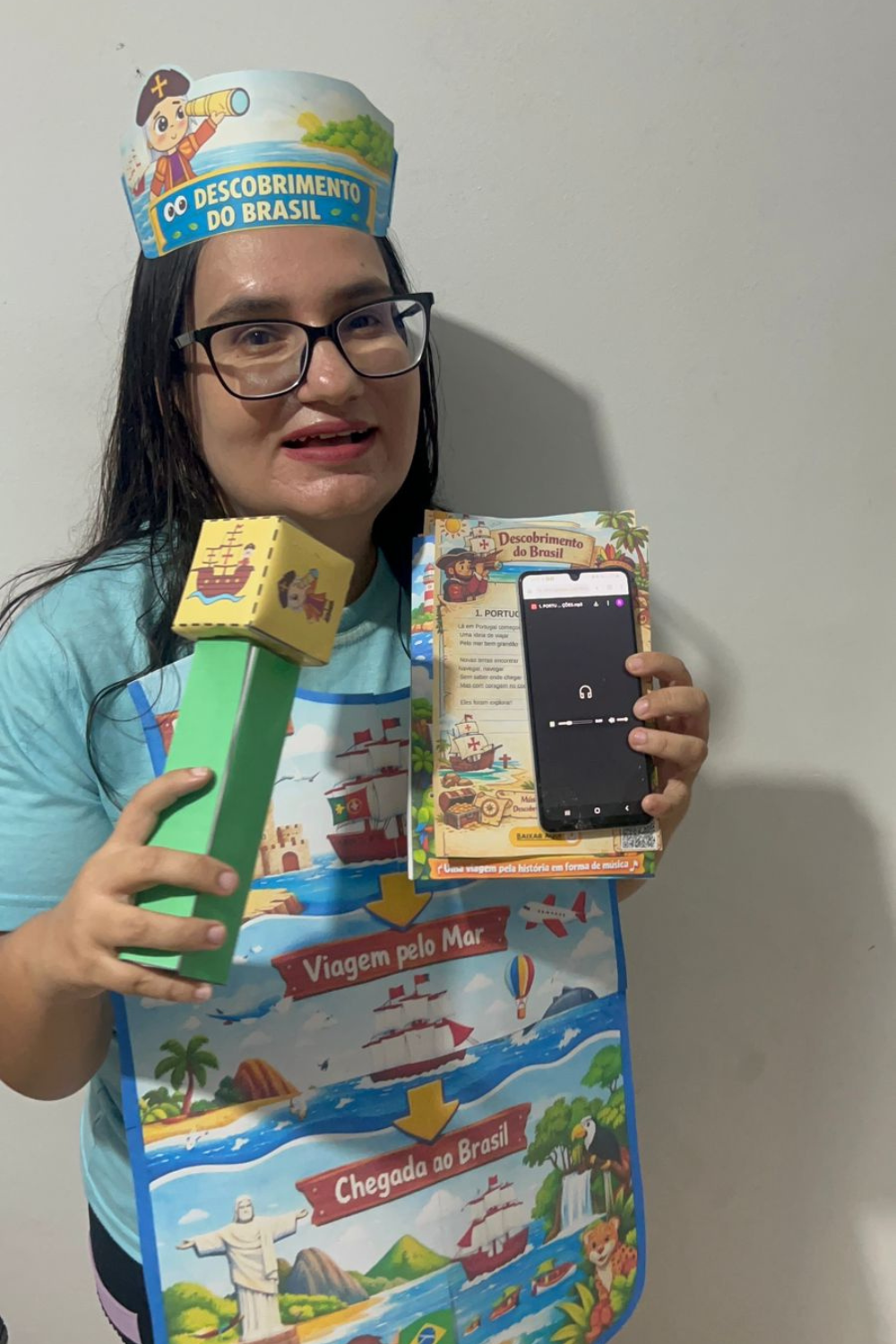 KIT COM CD PEDAGÓGICO, AVENTAL, MICROFONE E COROA DO DIA DO DESCOBRIMENTO DO BRASIL